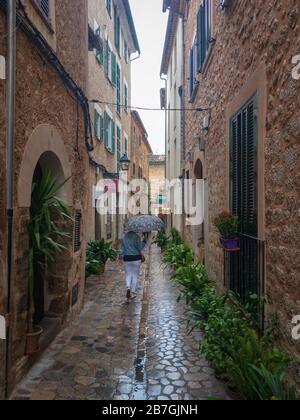 Soller, Espagne, - 24 mai 2019: Femme marchant avec un parapluie dans une allée dans la vieille ville de Soller sur l'île baléares de Majorque (Majorque), SPAI Banque D'Images