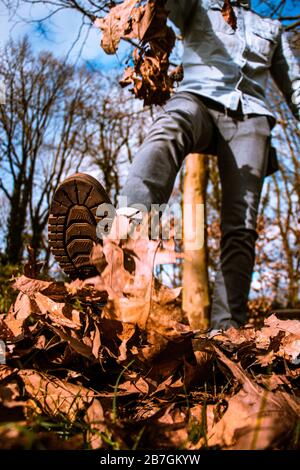 Un homme qui se kicking part dans l'air, ciel bleu, automne Banque D'Images