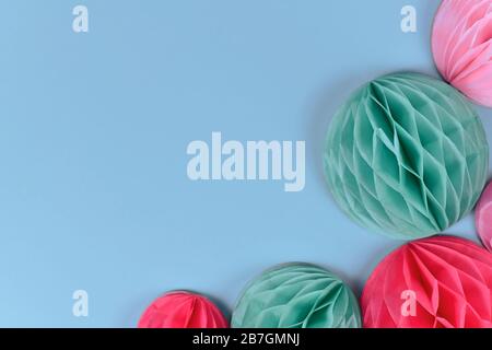 Boules de papier en forme de nid d'abeilles roses et bleues dans le coin du fond bleu pastel avec espace de copie vierge Banque D'Images