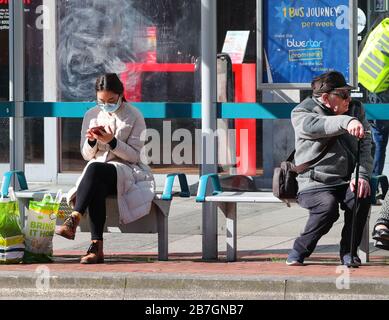 Southampton, Hampshire, Royaume-Uni. 16 mars 2020. Une femme portant un masque facial et un pensionné gardent leur distance tout en attendant un bus à Southampton. La ville a eu le premier cas confirmé de Coronavirus au cours du week-end. Crédit Stuart Martin/Alay Live News Banque D'Images