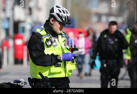 Southampton, Hampshire, Royaume-Uni. 16 mars 2020. Un agent de police du PCSO photographié avec un désinfectant pour les mains et portant des gants en caoutchouc à Southampton High Street. Southampton avait eu le premier cas confirmé de Coronavirus au cours du week-end. Crédit Stuart Martin/Alay Live News Banque D'Images