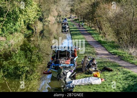 Un habitant de bateau lit un journal à côté de son bateau sur le canal de Kennett & Avon, entre Bradford on Avon et Bath. Banque D'Images