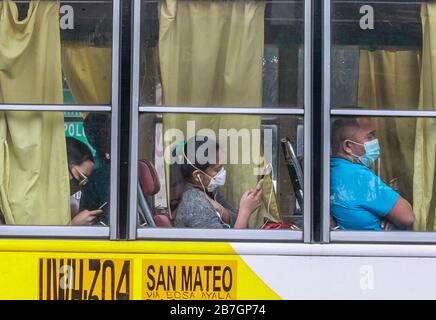 Quezon City. 16 mars 2020. Les passagers portant un masque sont vus à l'intérieur d'un autobus à un point de contrôle de Quezon City, aux Philippines, le 16 mars 2020. Le président philippin Rodrigo Duterte a placé toute l'île principale de Luzon aux Philippines sous la rubrique "renforcement de la quarantaine communautaire" dans une tentative radicale de contenir la propagation de la COVID-19 dans le pays, a déclaré le porte-parole présidentiel Salvador Panelo lundi. Les Philippines ont maintenant 140 cas confirmés de COVID-19, dont 12 décès. Crédit: Rouelle Umali/Xinhua/Alay Live News Banque D'Images