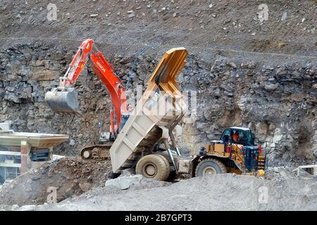 Un tombereau Caterpillar de 775 G et une pelle hydraulique Hitachi 360 travaillant à Coldstones Quarry, Greenhow Hill, Niddedale dans le North Yorkshire. Banque D'Images