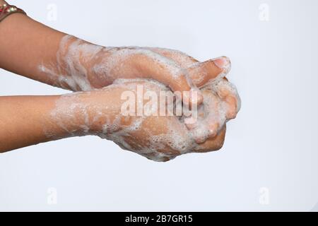 Une fille asiatique se laver les mains avec du savon isolé avec fond blanc. Concept d'hygiène.pour éviter le virus corona (covid-19). Mise au point sélective. Banque D'Images