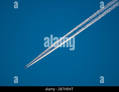 La piste du jet plane traverse le ciel de haut en bas à gauche Banque D'Images