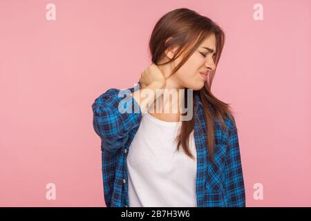 Portrait d'une femme fatiguée malsaine dans une chemise à damier massant un cou douloureux, souffrant de tension musculaire et de mal au dos du travail, se sentant fatiguée, moi Banque D'Images