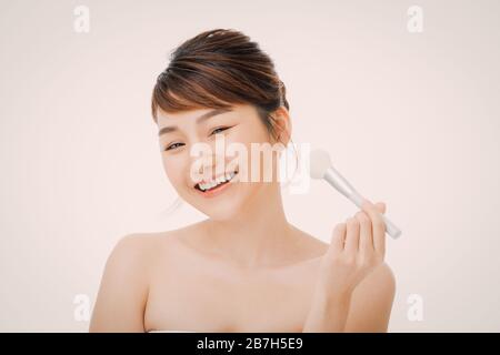 Portrait of young asian woman smile avec pinceau joue des soins de la peau et du concept esthétique. Banque D'Images