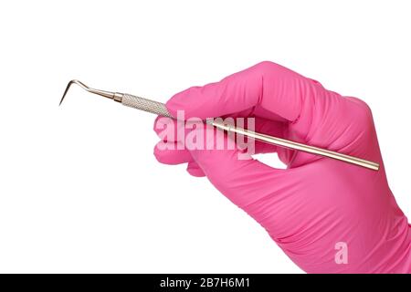 Vue rapprochée de la main du dentiste dans un gant en latex rose avec sonde sur fond blanc isolé. Concept d'outils médicaux. Banque D'Images