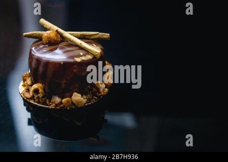 Gâteau au chocolat de luxe-gâteau décoré avec un décor d'or de popcorn caramélisé sur un fond sombre. Mise à plat. Close-up. Copier l'espace. Banque D'Images