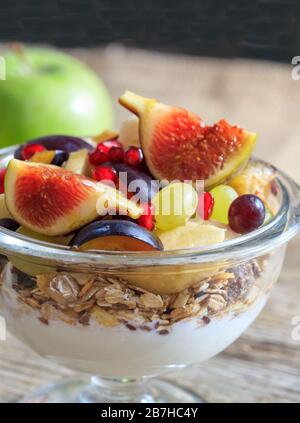 Petit déjeuner concept sain. Yaourt, muesli et fruits frais dans un bol, fond flou. Vue détaillée de la nourriture pour un style de vie sain. Banque D'Images