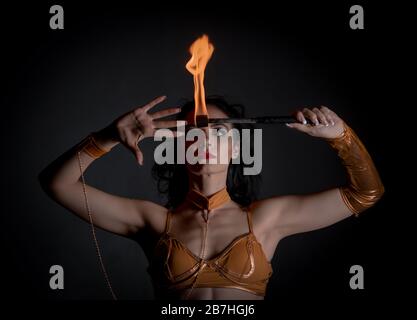 juggler fille exécutant des jeux de feu dans l'atmosphère sombre Banque D'Images