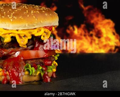 Délicieux hamburger maison savoureux avec viande et fromage et fond noir texturé.Concept de restauration rapide. Banque D'Images