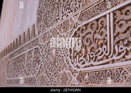 La calligraphie arabe sur les murs anciens du palais de l'Alhambra, site historique de Grenade, Espagne, construit pendant la dynastie musulmane islamique Banque D'Images