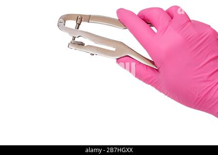 La main du dentiste dans le gant en latex rose avec poinçon dentaire sur fond blanc isilé. Concept d'outils médicaux. Banque D'Images