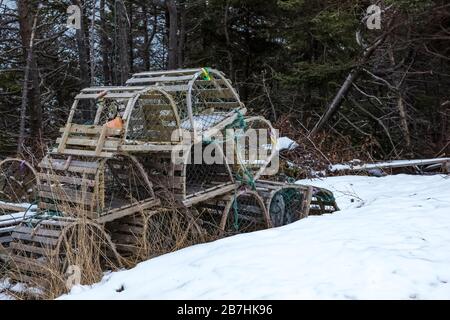 Casiers à homard en bois et en mesh stockés en dehors de la saison près d'une petite ville de Terre-Neuve, au Canada Banque D'Images