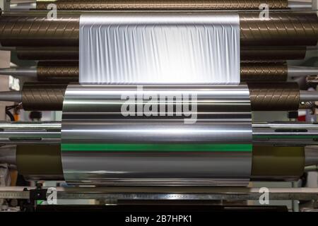 Rouleau de papier aluminium pour l'emballage des produits alimentaires sur la machine d'emballage automatique à l'usine de produits alimentaires industriels et de la technologie. concept. Banque D'Images