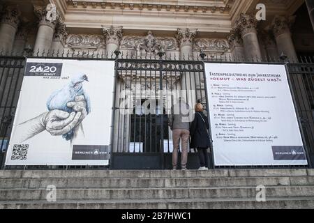 Berlin, Allemagne. 16 mars 2020. Deux piétons ont lu l'avis de clôture de la cathédrale de Berlin à Berlin, capitale de l'Allemagne, le 16 mars 2020. Les données de l'agence allemande de lutte contre la maladie ont montré que le nombre de cas confirmés de COVID-19 dans le pays a grimpé à 4 838 dimanche après-midi, soit 1 043 de plus que la veille. Le nombre de morts est passé à 12. Crédit: Shan Yuqi/Xinhua/Alay Live News Banque D'Images