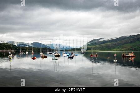 Des bateaux amarrés sur le Loch Broom, Ullapool, Écosse. Vue d'Ullapool sur le lac calme dans les Highlands écossais avec une couverture de nuages surcoulés. Banque D'Images