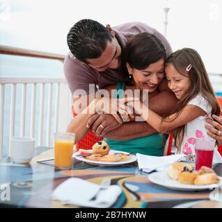Famille prenant le petit déjeuner sur le balcon de leur cabine à bord d'un bateau de croisière. Banque D'Images