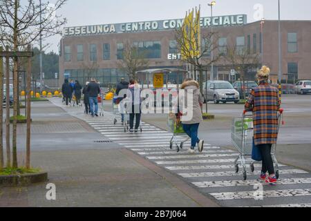 Ligne de personnes avec des chariots de shopping dans le parking de magasin d'épicerie. Les personnes se tenant à quelques mètres l'une de l'autre dans le cadre des restrictions de verrouillage Banque D'Images