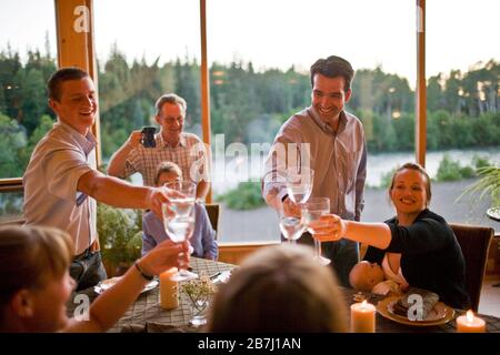 Family toasting at dinner table Banque D'Images