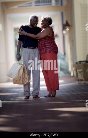 Heureux couple senior debout avec leurs bras autour l'un de l'autre. Banque D'Images