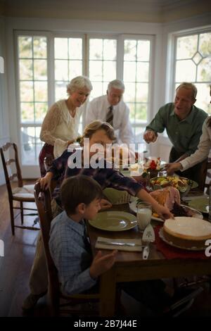 Heureuse famille réunis autour d'une table à manger le jour de Noël. Banque D'Images