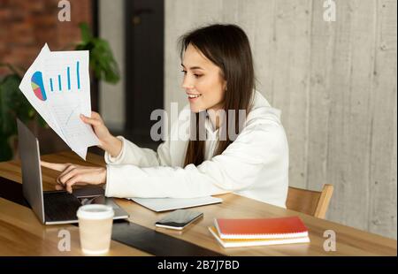 Indépendant travaille dans n'importe quel endroit pratique. Femme analyse les graphiques Banque D'Images