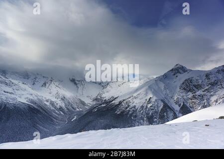 Le nuage de neige couvrait le sommet de la principale crête caucasienne près du village de ski de la station Dombay. La vue de la montagne Mussa-Achitara Banque D'Images