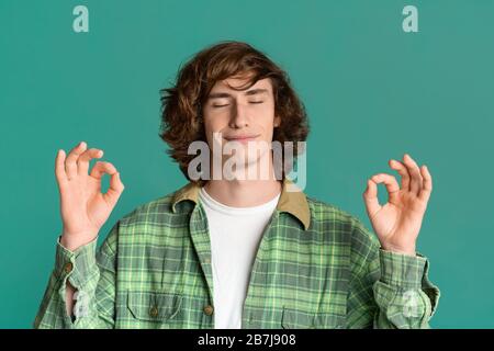 Gars funky avec yeux fermés méditant sur fond de couleur Banque D'Images