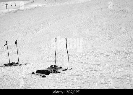 Équipement de ski : bâtons de ski, skis sur piste enneigée ensoleillée le jour de l'hiver. Image en noir et blanc. Banque D'Images