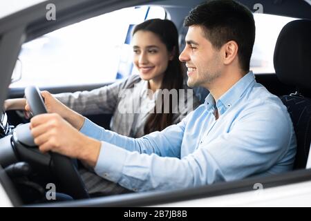 Femme et mari choisissant une voiture dans la boutique de la concession Banque D'Images