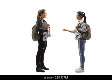 Photo de profil pleine longueur de deux étudiantes ayant une conversation isolée sur fond blanc Banque D'Images