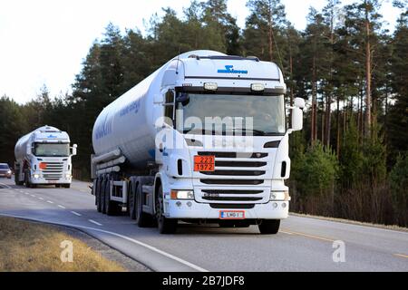 Deux camions-citernes blancs Scania semi-citernes Gasum transporte du GNL sur la route dans le sud de la Finlande au printemps. Code ADR 223-1972. Salo, Finlande. 13 mars 2020. Banque D'Images