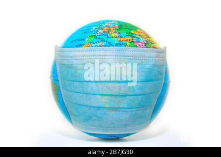 masque bleu jetable sur un monde malade isolé sur fond blanc. Concept de grippe épidémique et d'urgence pandémique dans le monde entier pour COVID 19 Banque D'Images