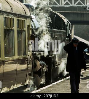 Un ingénieur ajuste son bouchon à côté d'un train à vapeur sur le chemin de fer East Lancashire à Ramsbottom, Lancashire, Angleterre Banque D'Images