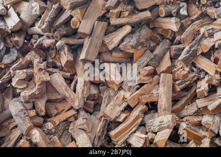 Bois de chauffage haché sur une pile. Fond de grumes de bois de chauffage hachés dans une pile. Texture, papier peint. Banque D'Images