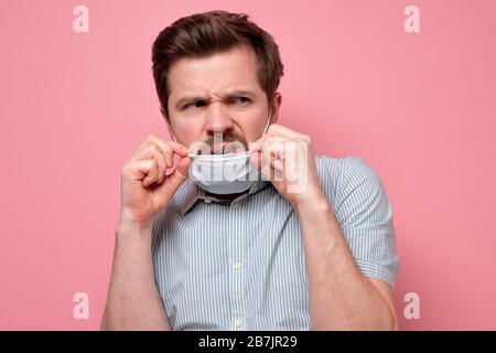 L'homme effrayé dans le masque hygiénique protecteur apravant l'épidémie de coronavirus, l'infection, les maladies respiratoires telles que la grippe, 2019-nCoV, ebola. Studio sh Banque D'Images