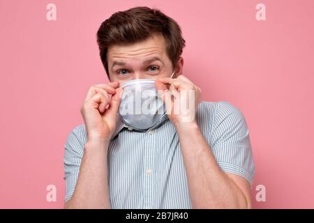 L'homme effrayé dans le masque hygiénique protecteur apravant l'épidémie de coronavirus, l'infection, les maladies respiratoires telles que la grippe, 2019-nCoV, ebola. Studio sh Banque D'Images