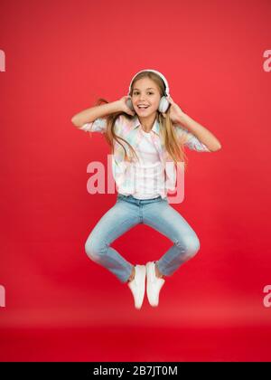 hipster kid continue de bouger. danse énergique des enfants. bonne enfance. inspirée de la musique. vacances printanières. fille célébrant la victoire. petite fille dans les écouteurs. plaisir en mouvement. petite star rock. Banque D'Images