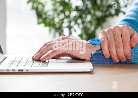 Gros plan de l'homme appliquant la compression à froid à un poignet douloureux causé par un travail prolongé sur l'ordinateur, ordinateur portable. Syndrome du tunnel carpien, arthrite, neu Banque D'Images