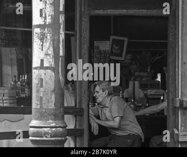 Juillet 1970 image film d'un homme assis et penchant sur un bar avec un panneau DE BARRE en premier plan. Côté est inférieur, New York City. Banque D'Images