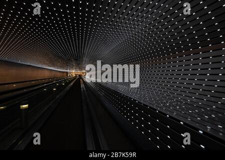 Installation lumineuse Multiverse de la National Gallery of Art Washington D.C. // WASHINGTON D.C. (États-Unis) — L'installation lumineuse Multiverse de l'artiste Leo Villareal illumine la passerelle mobile entre les bâtiments est et Ouest de la National Gallery of Art. Cette œuvre d'art immersive présente des milliers de lumières LED créant des motifs dynamiques, offrant aux visiteurs un voyage fascinant à travers un tunnel de lumière en constante évolution. Banque D'Images