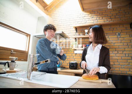 Grand-mère et petit-fils qui parlent avec le sourire dans la cuisine Banque D'Images