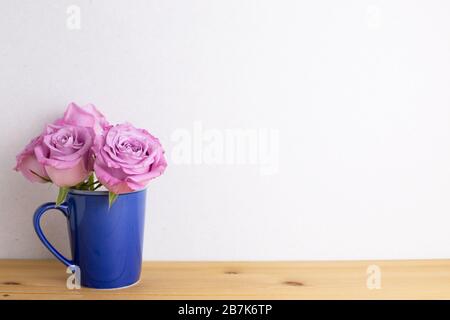 Fleurs roses violettes en céramique sur table en bois avec fond blanc. Arrangement de fleurs de printemps, espace de copie Banque D'Images