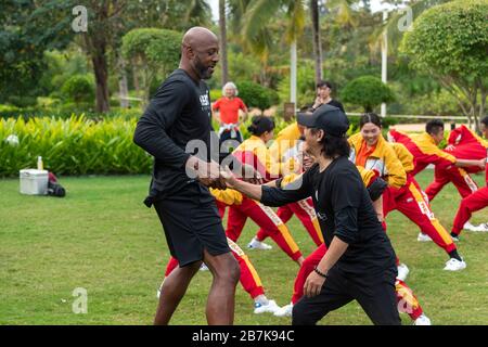 Alonzo Mourning, à gauche, l'exécutif américain de basket-ball professionnel et l'ancien joueur et artiste martial chinois Jet Li, jouent le tai chi avec les gens au Banque D'Images