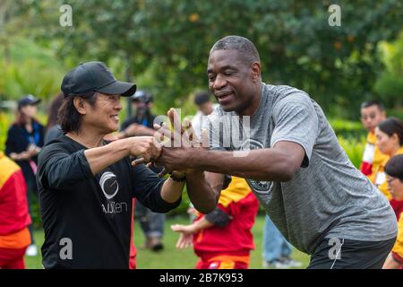 Dykembe Mutombo, à droite, joueur de basket-ball professionnel à la retraite congolais-américains et Jet Li, artiste martial chinois jouent le tai chi avec des gens au m Banque D'Images