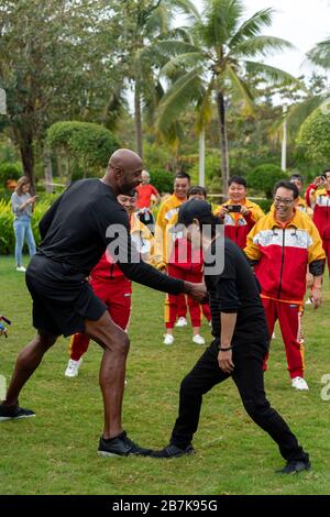 Alonzo Mourning, à gauche, l'exécutif américain de basket-ball professionnel et l'ancien joueur et artiste martial chinois Jet Li, jouent le tai chi avec les gens au Banque D'Images