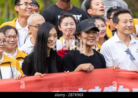 L'artiste martial chinois Jet Li, du milieu, et sa fille, à gauche, prennent des photos avec les gens après l'exercice matinal tai chi du Jack 2019 Banque D'Images